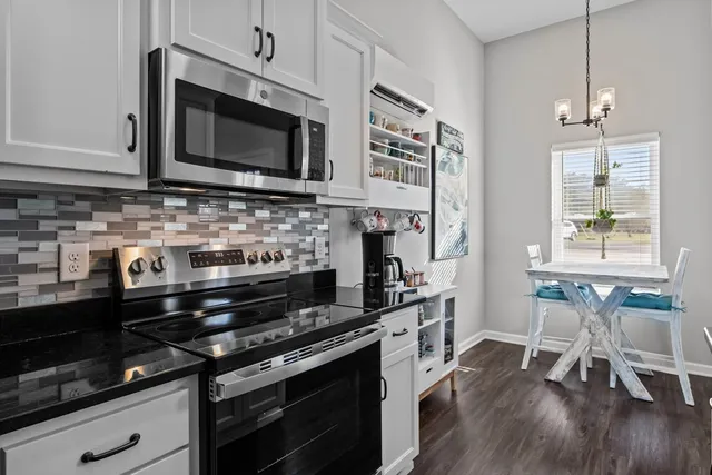 a kitchen with stainless steel appliances a stove microwave and cabinets