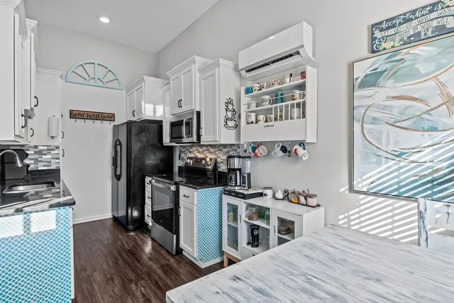 a kitchen with stainless steel appliances a stove a refrigerator and a wooden floor