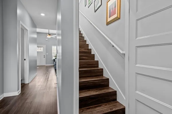 a view of a hallway with wooden floor and staircase
