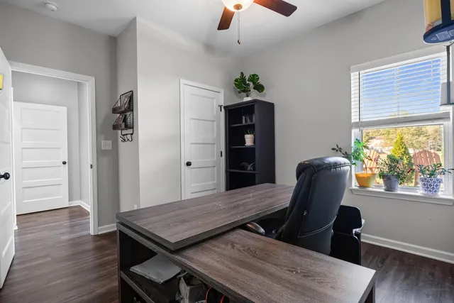 a view of a workspace with furniture and a window