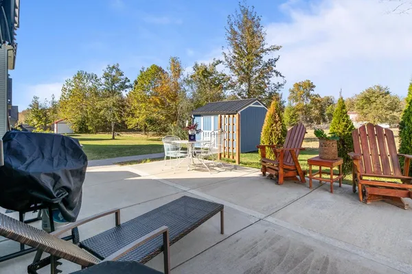 a view of a backyard with swimming pool and sitting area