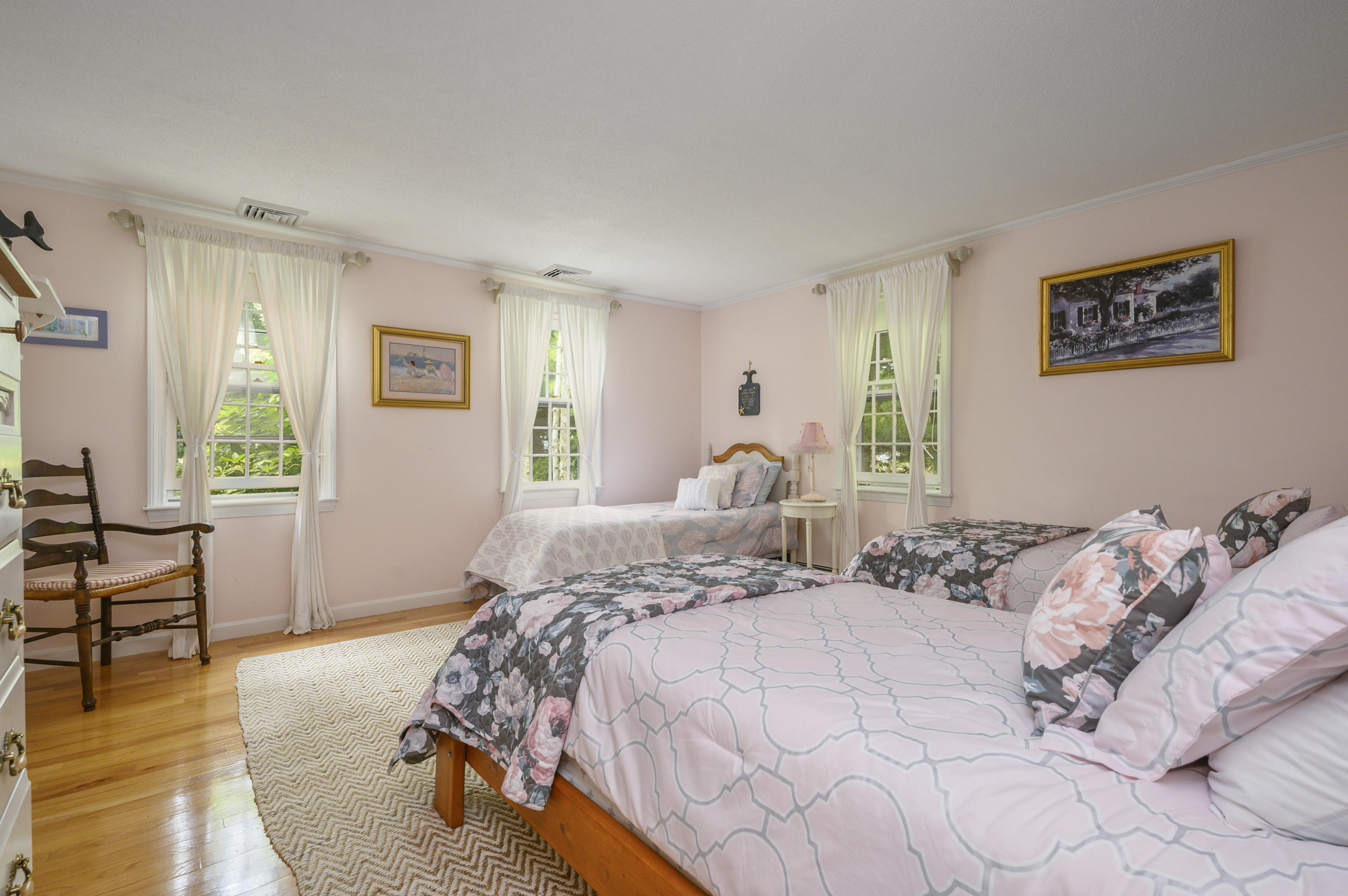 624 Lumbert Mill Road Centerville, MA 02632 - Photo 10 of 20 a bed sitting in a bedroom next to a window with chair and wooden floor