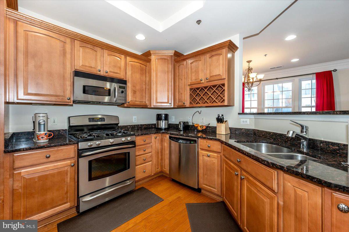 3541 Huntley Manor Lane, Unit 79B Alexandria, VA 22306 - Photo 14 of 40 a kitchen with stainless steel appliances granite countertop a stove sink microwave and window