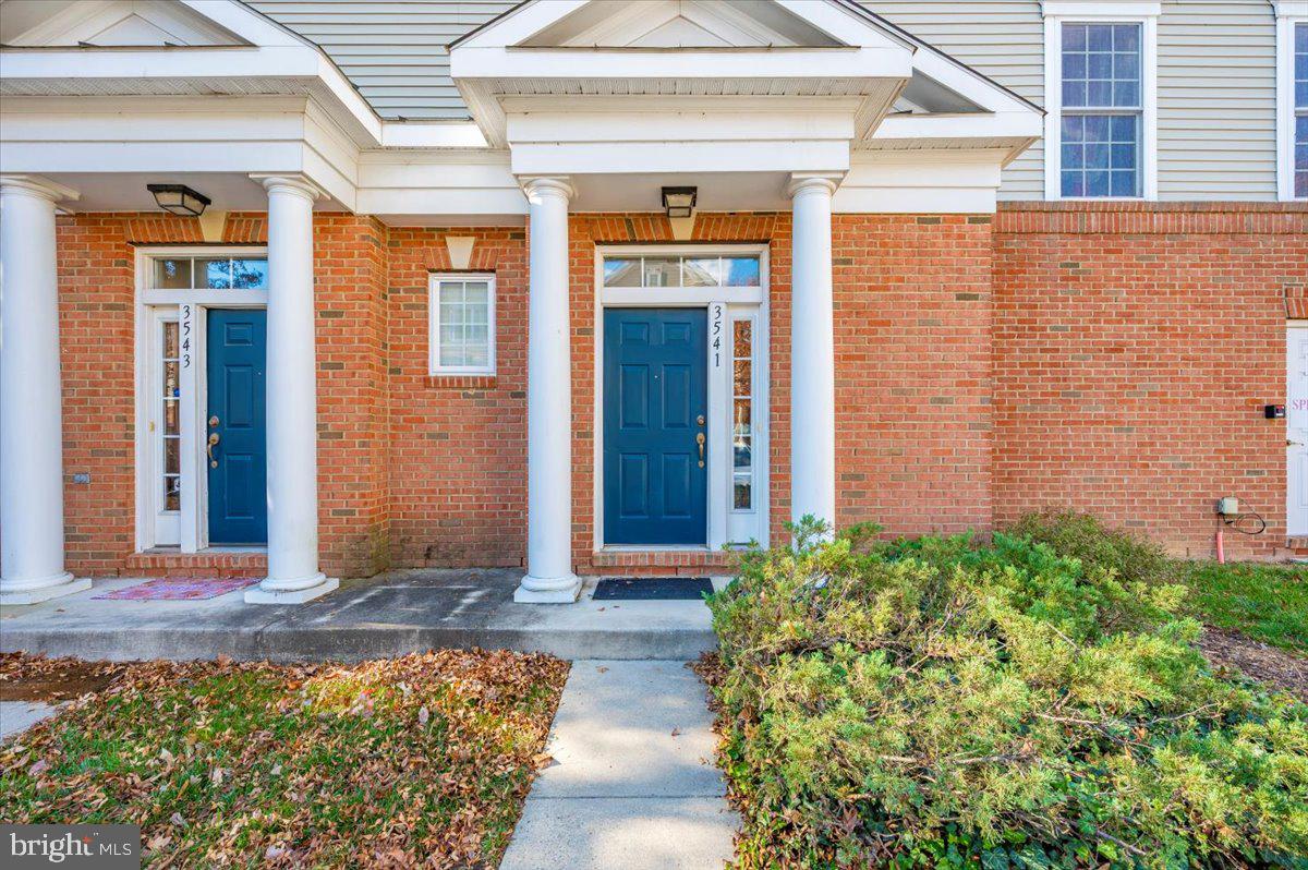 3541 Huntley Manor Lane, Unit 79B Alexandria, VA 22306 - Photo 35 of 40 front view of a brick house with potted plants