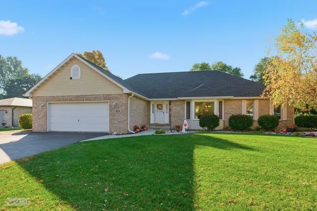 a front view of a house with a yard and garage