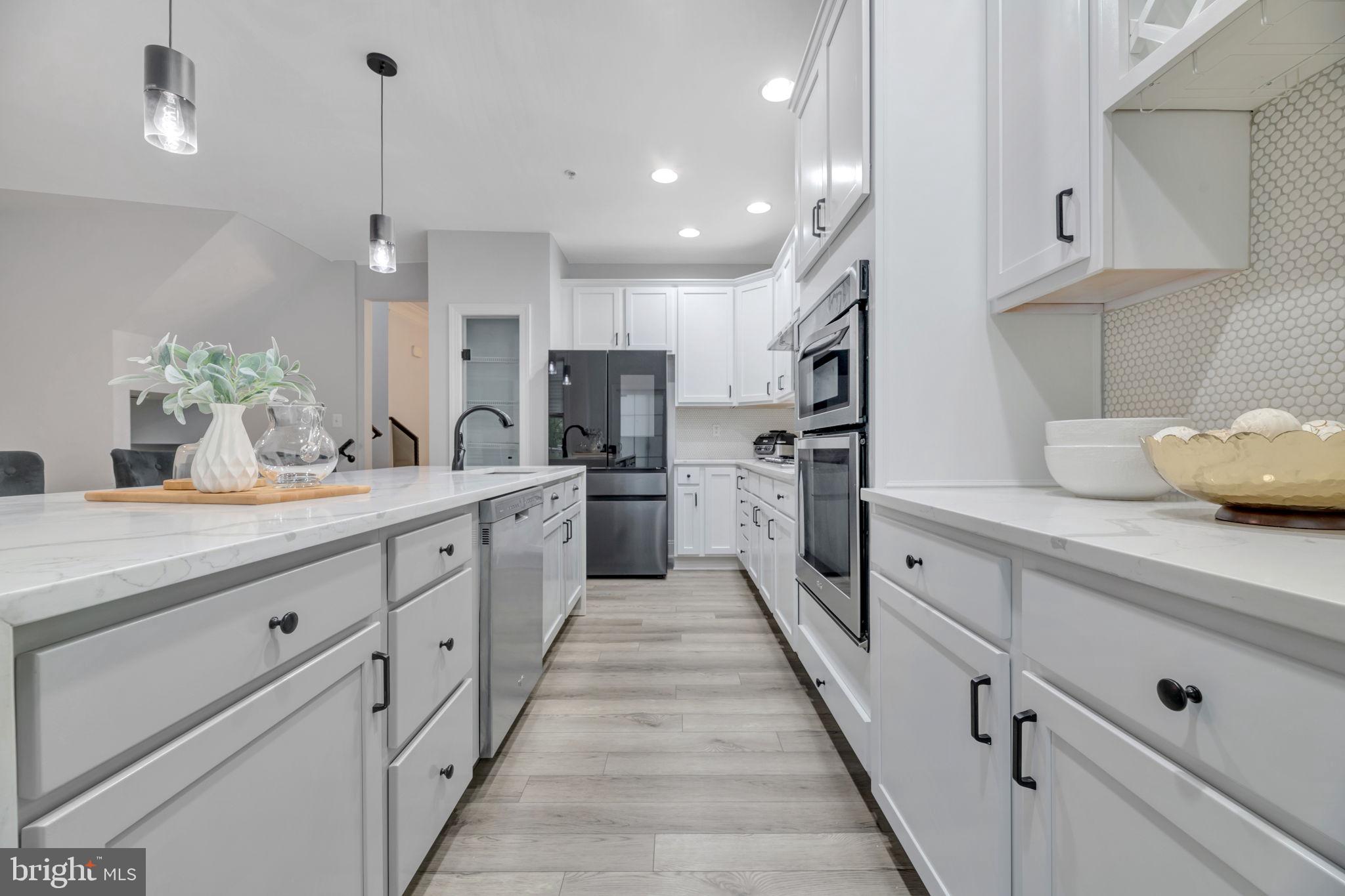 a large kitchen with stainless steel appliances kitchen island granite countertop a sink and cabinets