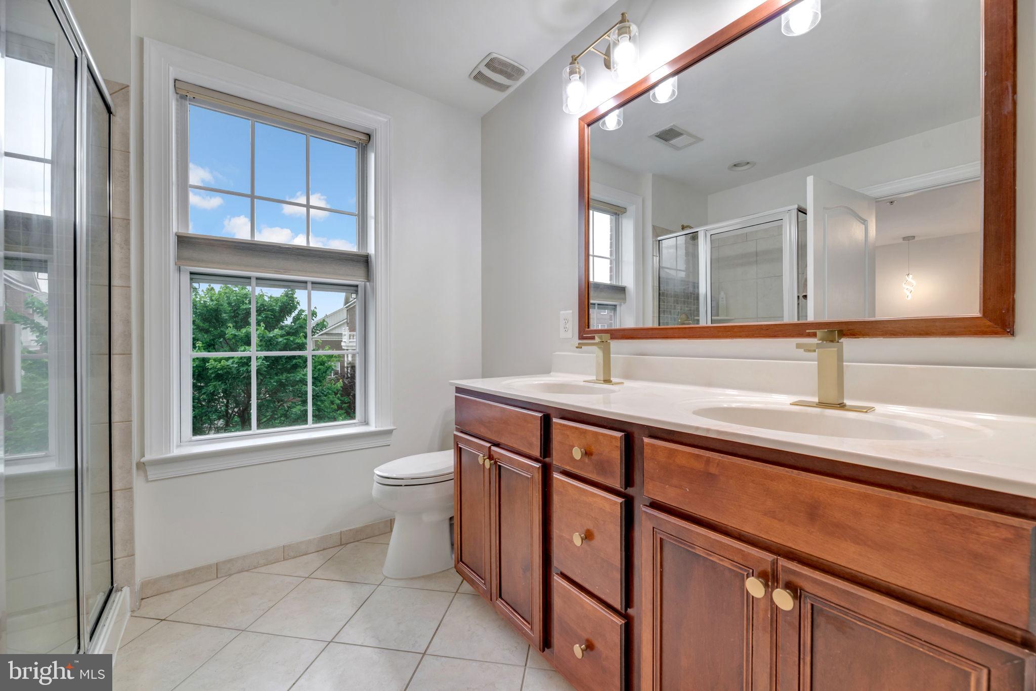 7619 Elmcrest Road Hanover, MD 21076 - Photo 18 of 35 a spacious bathroom with a granite countertop sink a toilet and a window