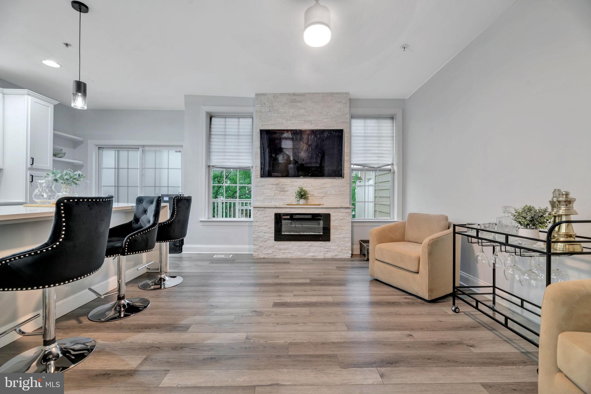 7619 Elmcrest Road Hanover, MD 21076 - Photo 6 of 35 a living room with furniture a flat screen tv and a fireplace