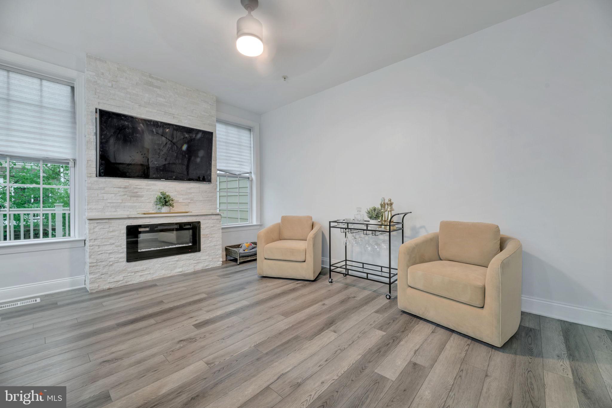 7619 Elmcrest Road Hanover, MD 21076 - Photo 7 of 35 a living room with furniture a flat screen tv and a fireplace