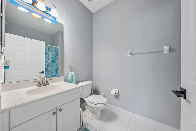 a bathroom with a toilet a sink a mirror and a shower