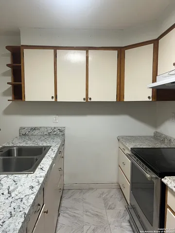 a kitchen with a sink stove and cabinets