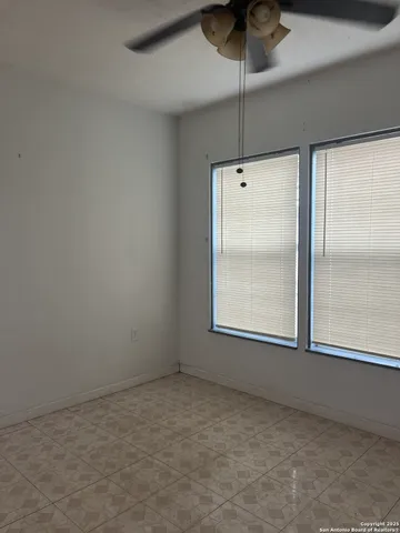 an empty room with a window and a ceiling fan