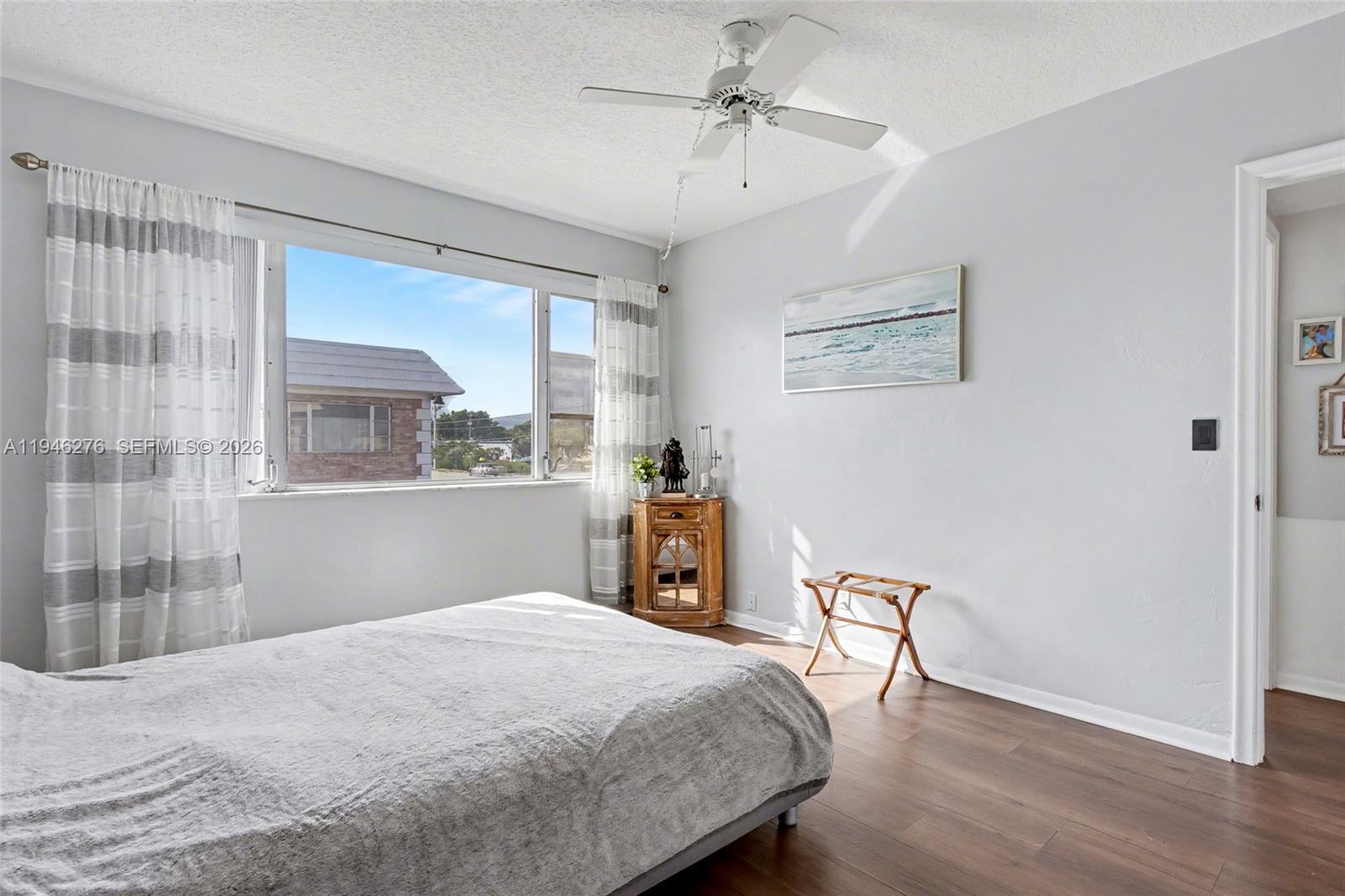 412 South Cypress Road, Unit 222 Pompano Beach, FL 33060 - Photo 11 of 24 a bedroom with a bed and wooden floor