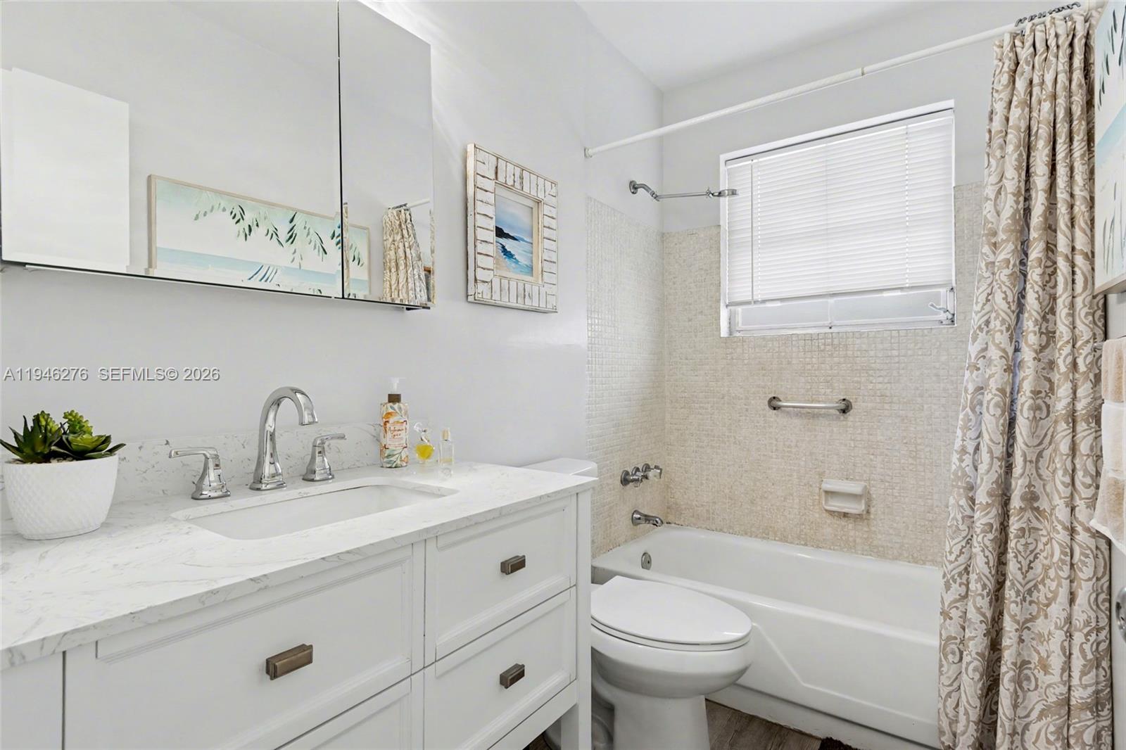 412 South Cypress Road, Unit 222 Pompano Beach, FL 33060 - Photo 12 of 24 a bathroom with a sink a mirror a toilet and bathtub