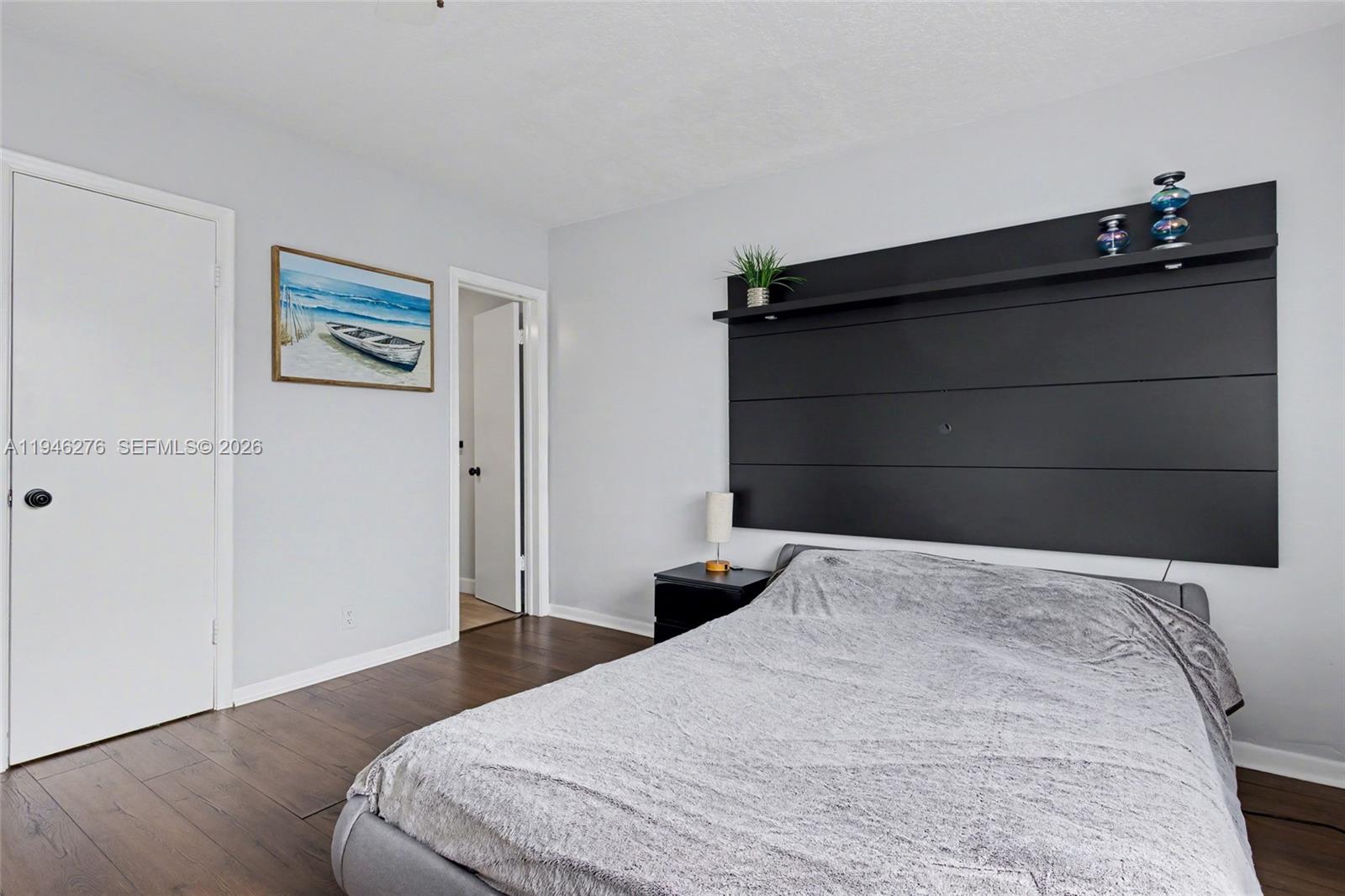 412 South Cypress Road, Unit 222 Pompano Beach, FL 33060 - Photo 13 of 24 a bedroom with a bed and wooden floor