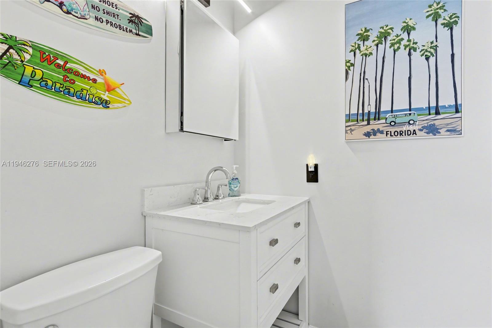412 South Cypress Road, Unit 222 Pompano Beach, FL 33060 - Photo 21 of 24 a bathroom with a sink a toilet and a mirror
