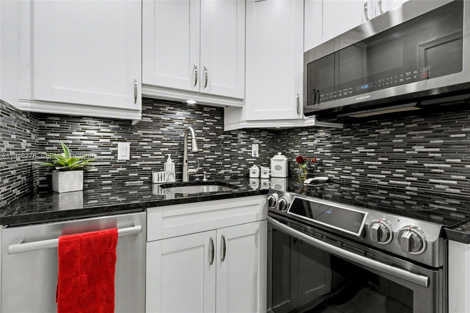 412 South Cypress Road, Unit 222 Pompano Beach, FL 33060 - Photo 3 of 24 a kitchen with stainless steel appliances granite countertop a sink stove and microwave