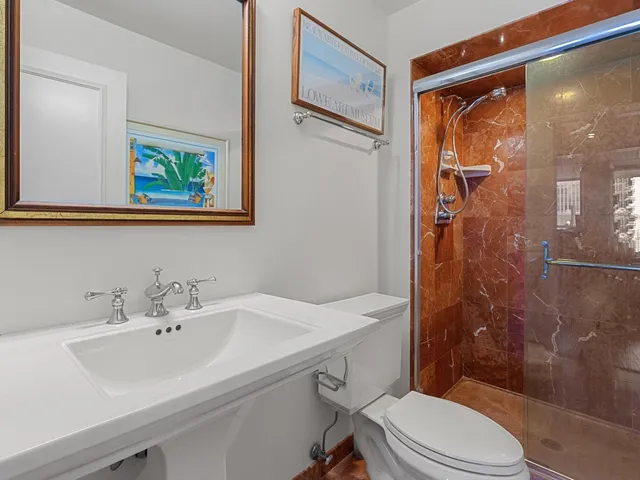 a bathroom with a sink mirror toilet and shower