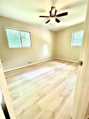 a view of a room with a ceiling fan and a window