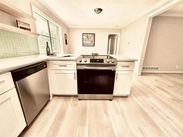 a kitchen with stainless steel appliances granite countertop a stove a sink and a refrigerator