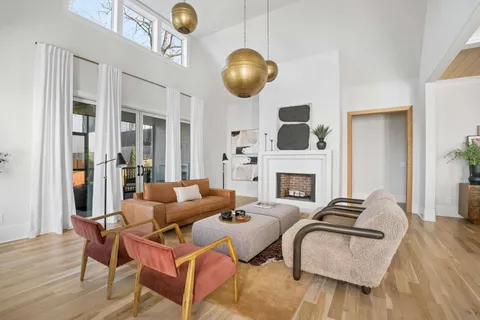 a kitchen with stainless steel appliances granite countertop a stove a sink a refrigerator and a dining table with wooden floor
