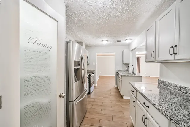 a kitchen with stainless steel appliances granite countertop a refrigerator and a sink