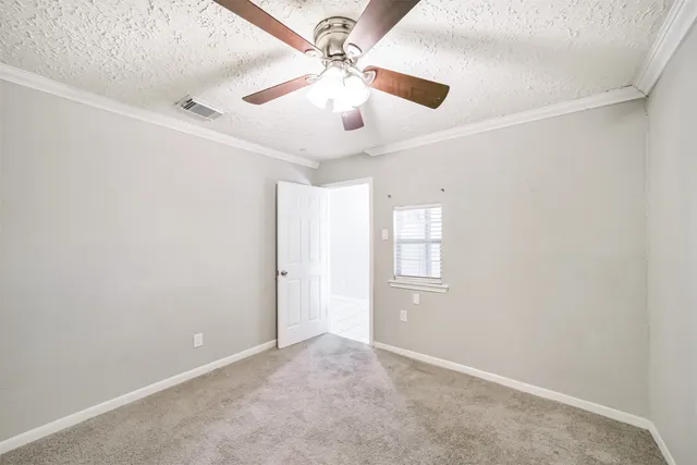 an empty room with windows and fan
