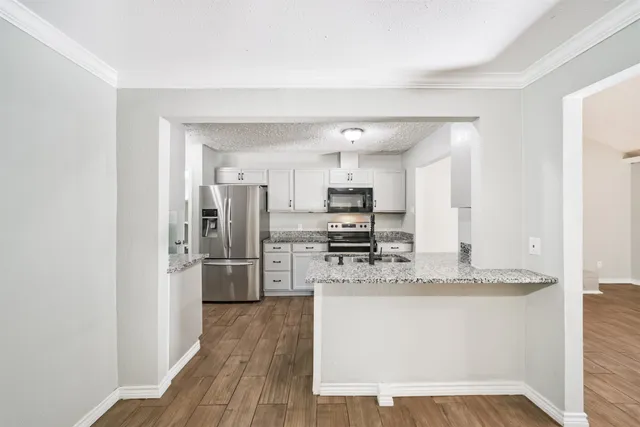 a kitchen with stainless steel appliances a refrigerator and a stove top oven