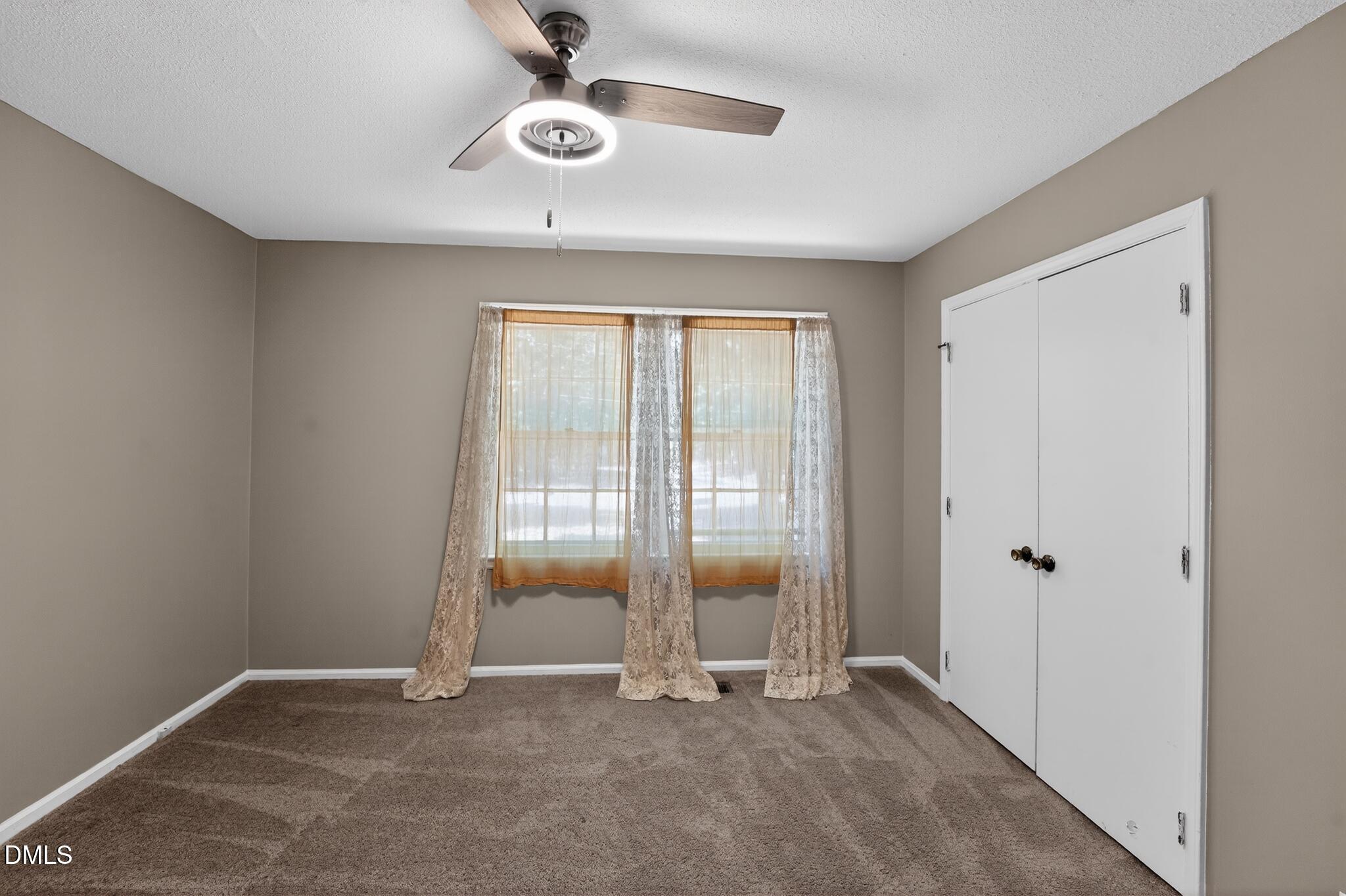 1034 Jerome Road Durham, NC 27713 - Photo 25 of 35 an empty room with ceiling fan and windows