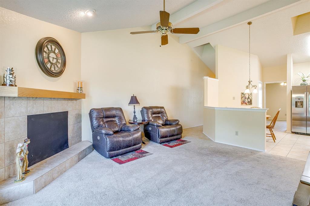 1116 Highpoint Road Bedford, TX 76022 - Photo 11 of 37 Tiled living area featuring a fireplace, carpet flooring, beamed ceiling, a ceiling fan, and high vaulted ceiling