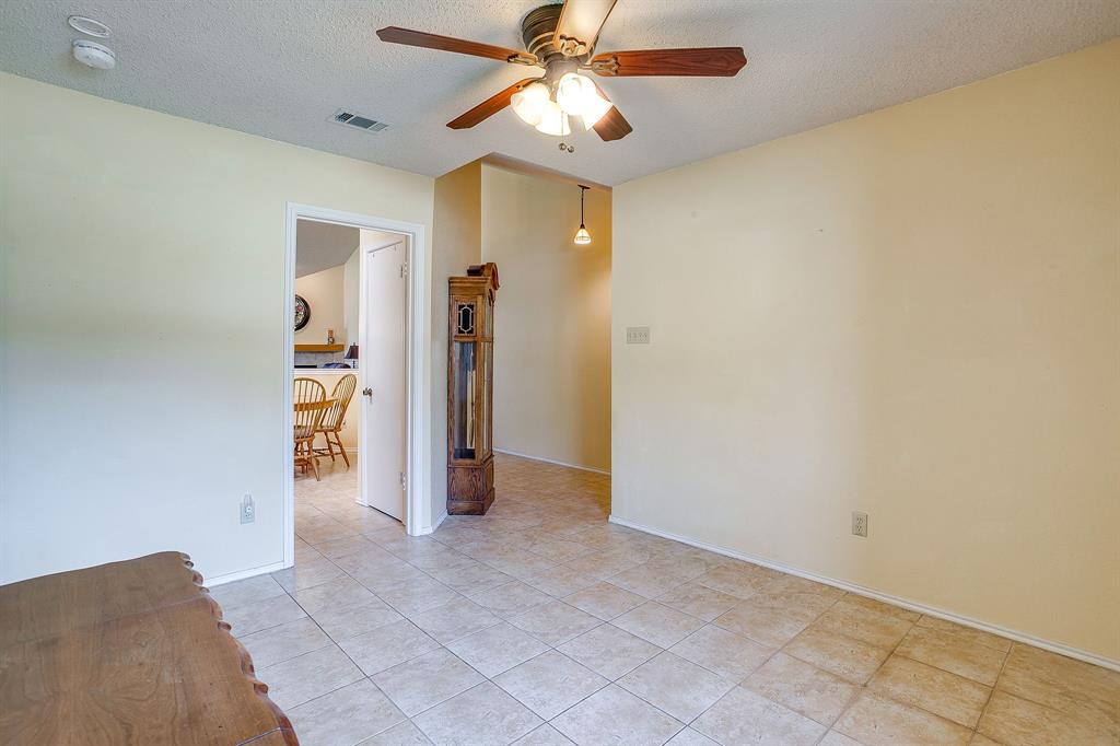 1116 Highpoint Road Bedford, TX 76022 - Photo 6 of 37 Empty room with a textured ceiling, a ceiling fan, and light tile patterned floors