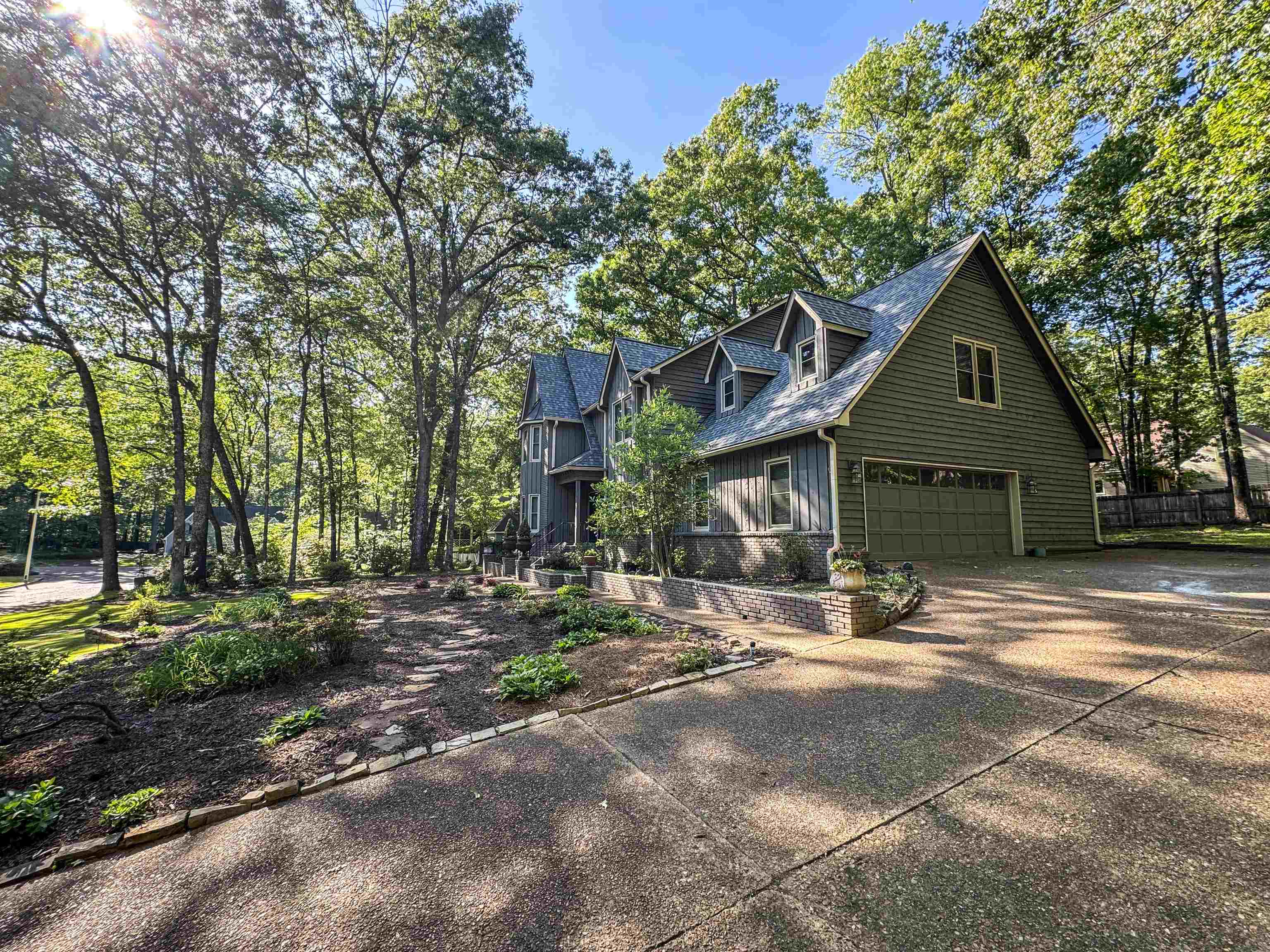 832 South Tree Drive Collierville, TN 38017 - Photo 37 of 40 Crafted exterior featuring green siding, a steeply pitched roof, dormer windows, and an attached two-car garage