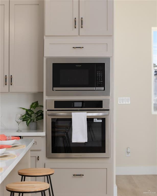 7820 North 38th Street McAllen, TX 78504 - Photo 8 of 31 Kitchen featuring oven, built in microwave, white cabinets, and light stone counters