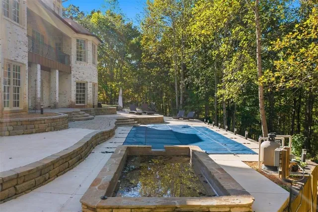 a view of a house with backyard and trees