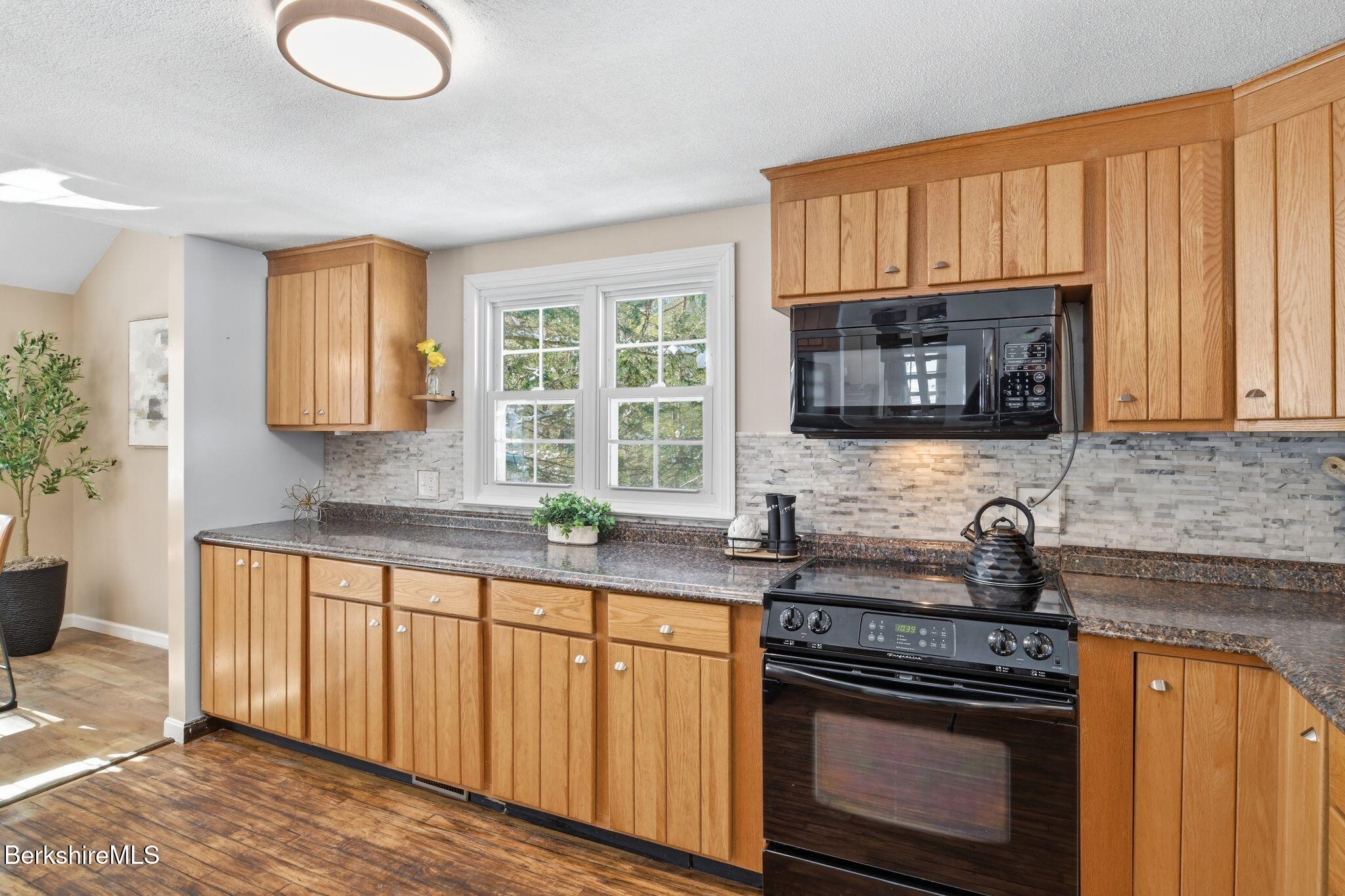 30 Gore Road Blandford, MA 01008 - Photo 16 of 61 a kitchen with granite countertop a stove a sink and a microwave