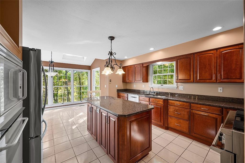 409 Bryn Court Pittsburgh, PA 15237 - Photo 16 of 50 a kitchen with granite countertop a stove a sink dishwasher and a refrigerator with wooden cabinets