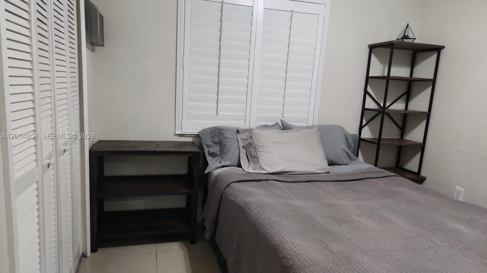 1935 Northwest 96th Street Miami, FL 33147 - Photo 2 of 7 a bedroom with a bed and a window