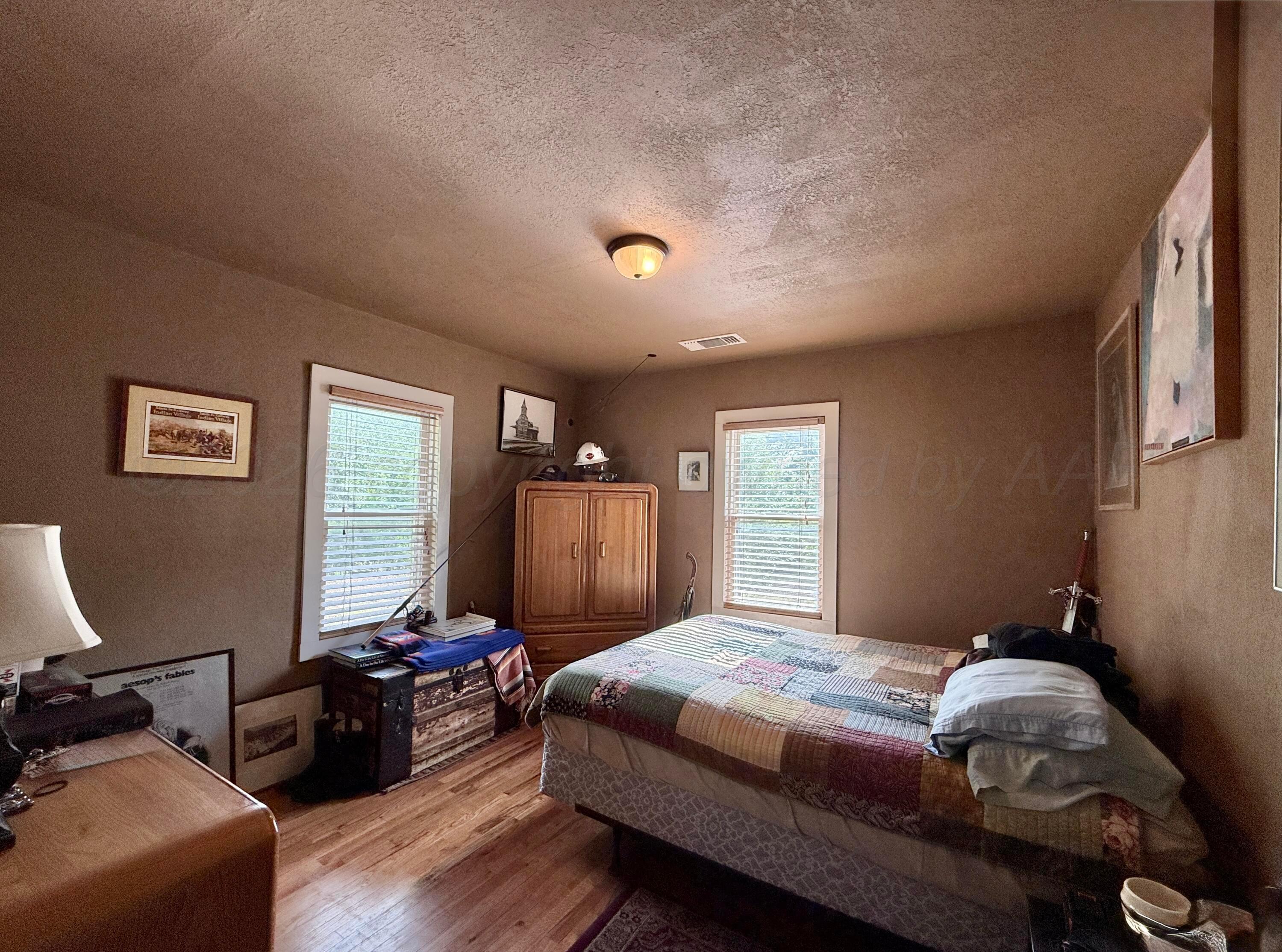 701 Brain Street Borger, TX 79007 - Photo 12 of 18 a bedroom with a bed and wooden floor