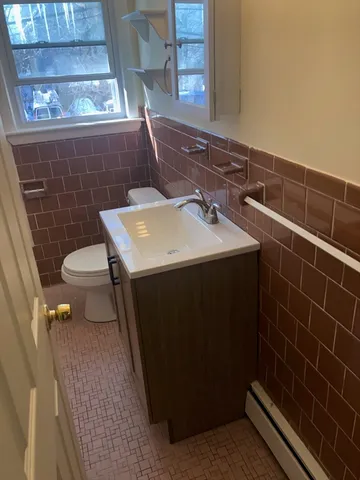 a bathroom with a sink a toilet and a mirror