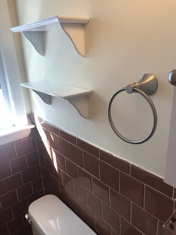 a bathroom with a toilet and a mirror
