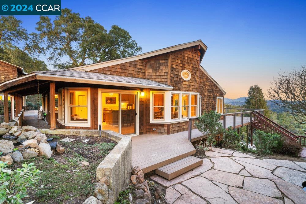 70 El Gavilan Road Orinda, CA 94563 - Photo 1 of 1 a view of patio with a table and chairs under an umbrella with a large tree