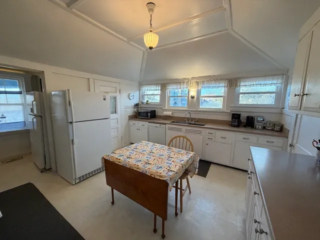 a kitchen with a table chairs stove and cabinets