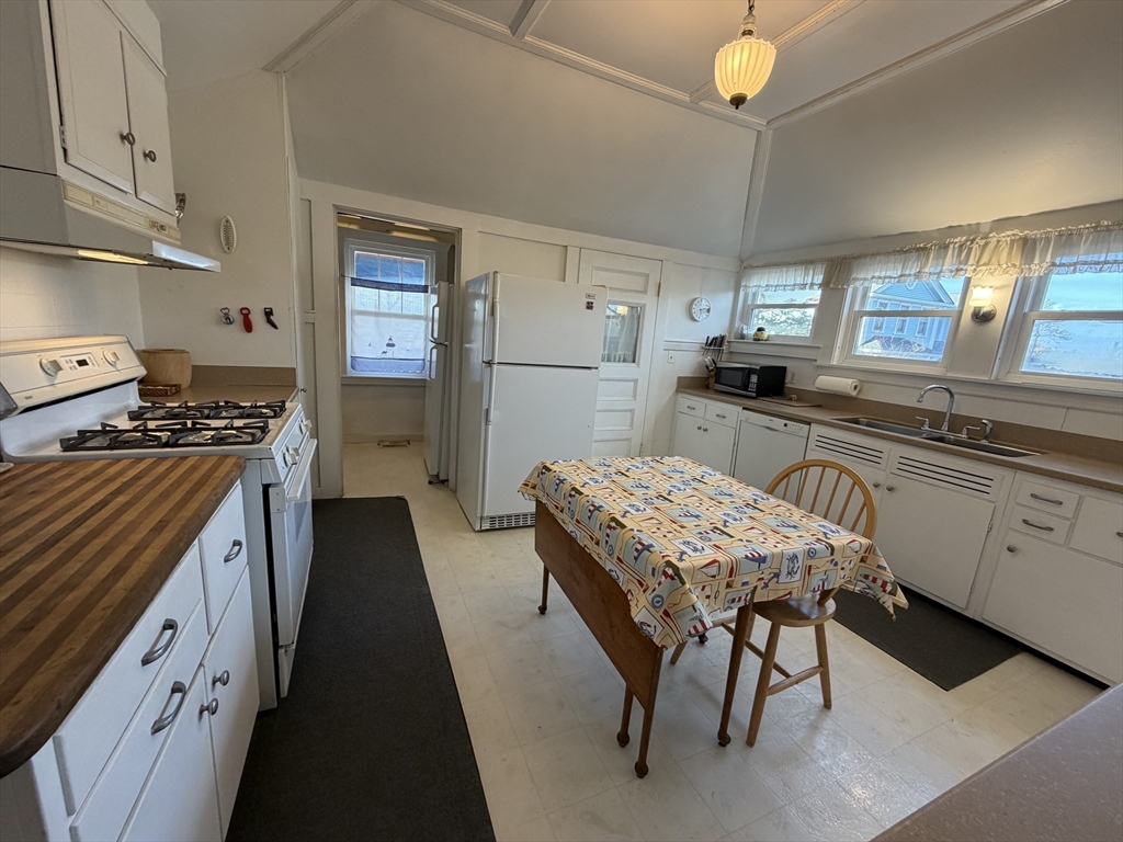 630 Washington Street, Unit 1 Gloucester, MA 01930 - Photo 13 of 28 a kitchen with a table chairs stove and cabinets