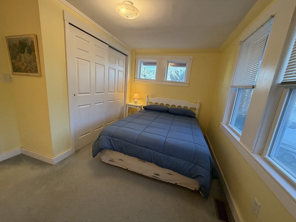 630 Washington Street, Unit 1 Gloucester, MA 01930 - Photo 19 of 28 a bedroom with a bed and wooden floor