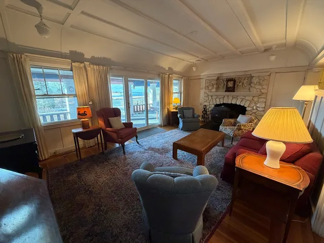 a living room with furniture a fireplace and large windows