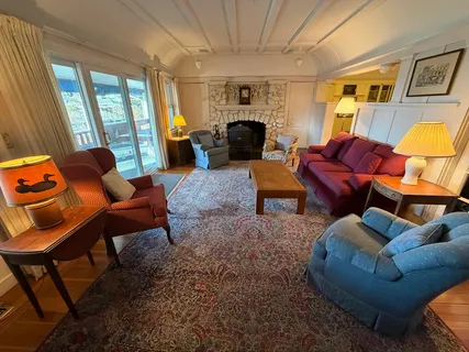 a living room with furniture a fireplace and large windows