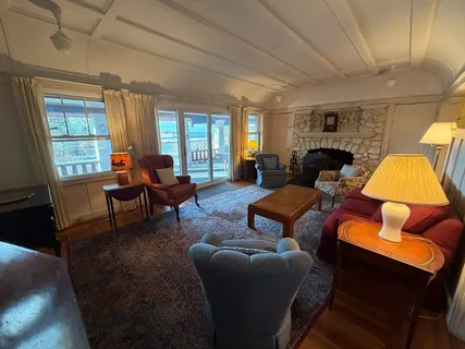 a living room with furniture a fireplace and large windows