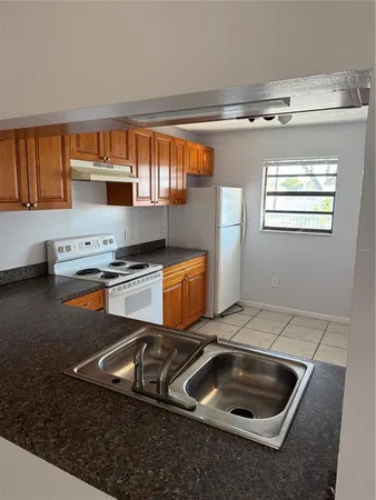 a kitchen with stainless steel appliances granite countertop a sink stove and white cabinets