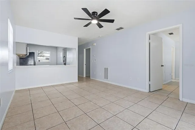 a view of a livingroom with a chandelier fan and windows