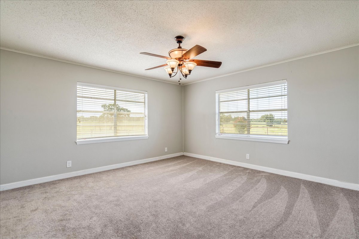 595 Cardinal Road Rosanky, TX 78953 - Photo 18 of 39 an empty room with windows and chandelier fan